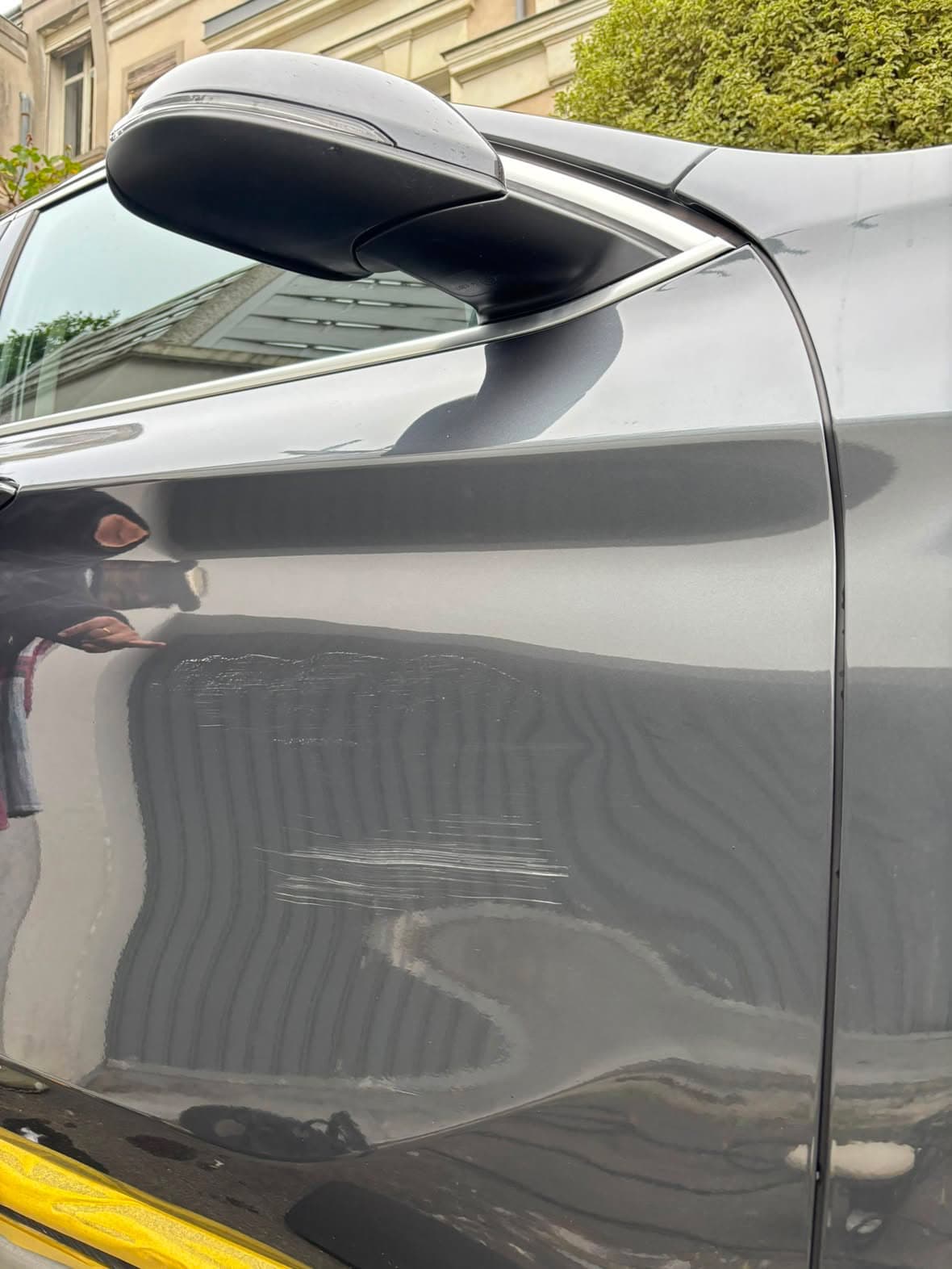 Rayure sur la portière d'un BMW X1 effacée par un lustrage minute à domicile — avant intervention